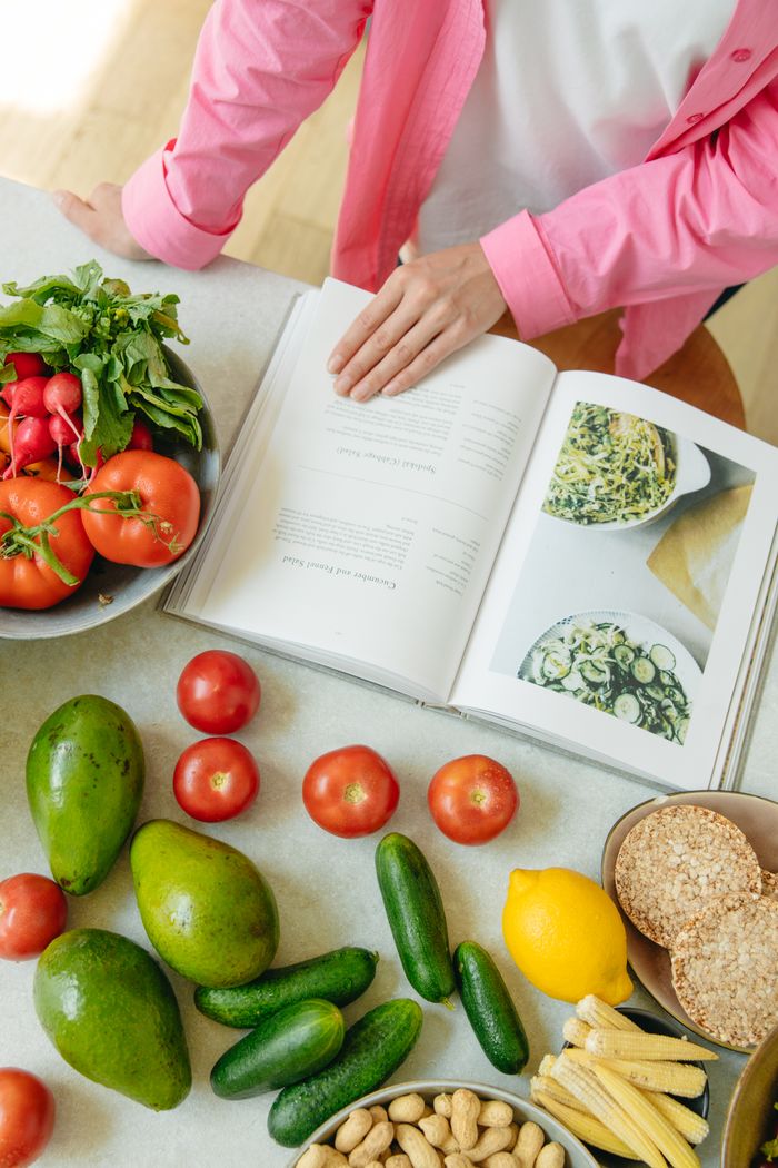 The Art of Drawing Readers In: Your attractive post title goes here Overhead view of fresh vegetables and an open cookbook on a kitchen counter.